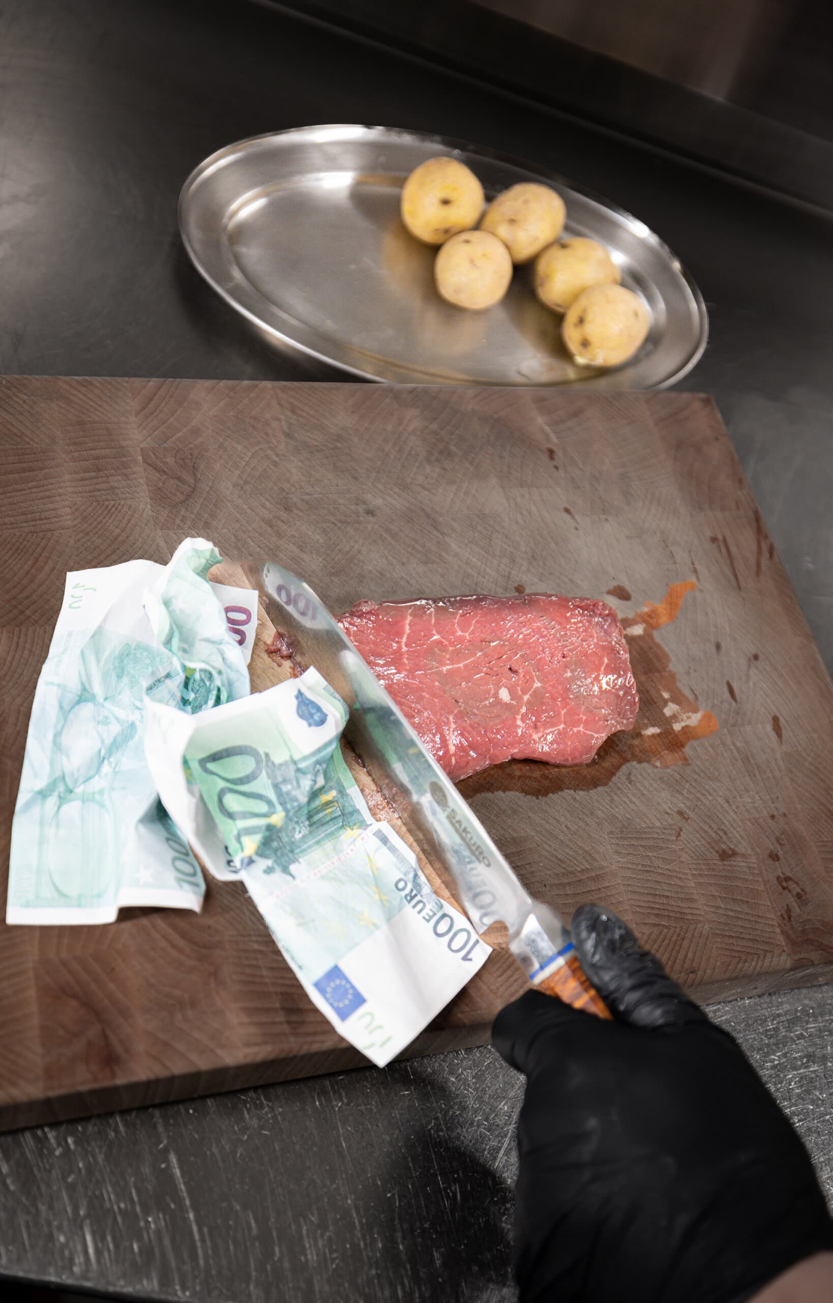 A vacuum-packed steak with banknotes sealed alongside it